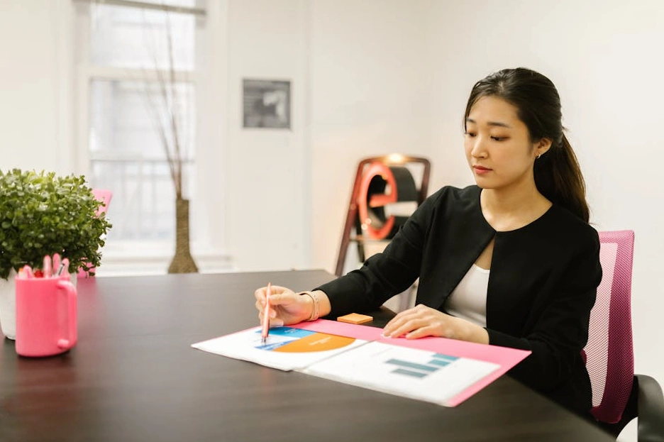 Una dirigente firma un documento importante nel suo ufficio con vista sulla città.